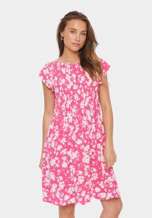 Roze bloemenjurk met korte gerimpelde mouwen, smock-borststuk, knielange snit en een levendig wit bloemenpatroon op een heldere achtergrond.
