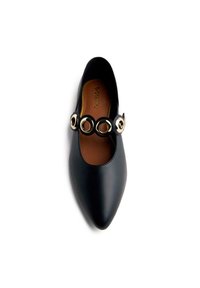 Black leather pointed-toe shoe with a brown insole and a decorative strap featuring circular gold accents. Smooth texture with minimalist design.