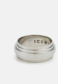 Sølvring med rund form, med en glatt overflate, to horisontale spor, og innrisset "ICON" på innsiden. Pusset metallisk finish.