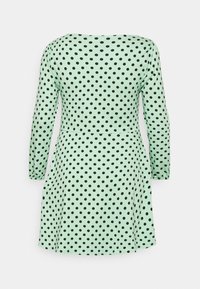 Vestido de manga curta em tecido verde menta com bolinhas pretas. Design evasê com decote redondo e cintura ajustada. Textura suave por toda a peça.