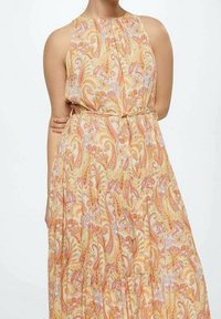 Robe sans manches avec col halter et taille nouée, avec une jupe fluide et un motif paisley dans des tons doux orange, rose et jaune.