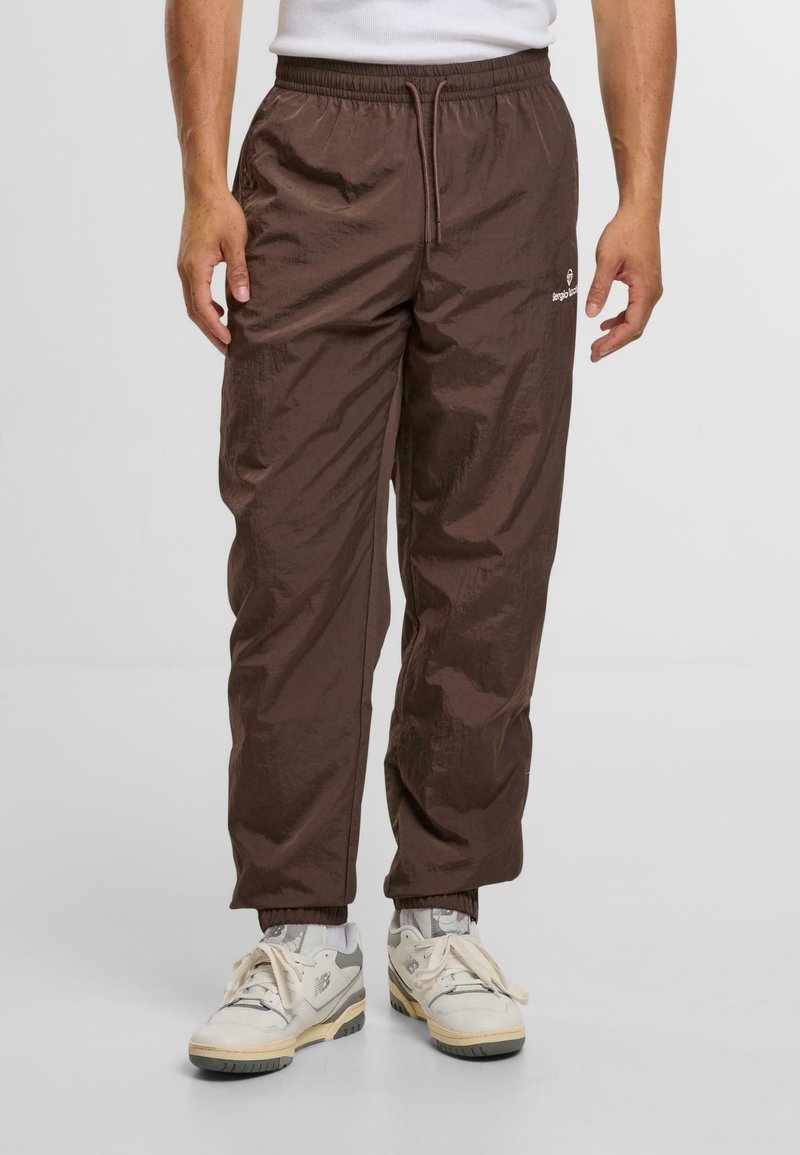 Brązowe, lekkie spodnie wykonane z błyszczącej, teksturowanej tkaniny. Posiadają elastyczny pas i sznurek, z mankietami przy kostkach.