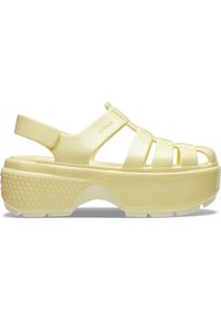 Żółta plastikowa sandałka z otwartym noskiem, z paskami i grubą podeszwą platformową z teksturowanym gripem. Widoczne logo.