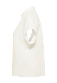 Blouse blanche à manches courtes avec un col pointu, vue de côté sur fond blanc.