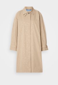 Trench-coat beige longueur genou avec un motif floral discret, col classique, manches longues et fermeture par boutons au niveau du col.