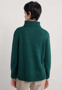 Grön stickad tröja med hög ribbad krage, avslappnad passform och ribbade muddar. Texturen är mjuk med en subtil melerad effekt.