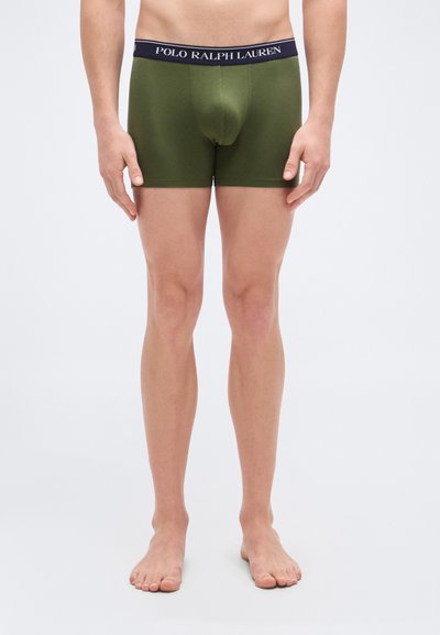 Εσώρουχα boxer σε ελαιώδες πράσινο με μπλε σκούρο λάστιχο μέσης που φέρει την ένδειξη "POLO RALPH LAUREN." Το ύφασμα φαίνεται μαλακό και ελαστικό, προσαρμοσμένο στενά στο σώμα.