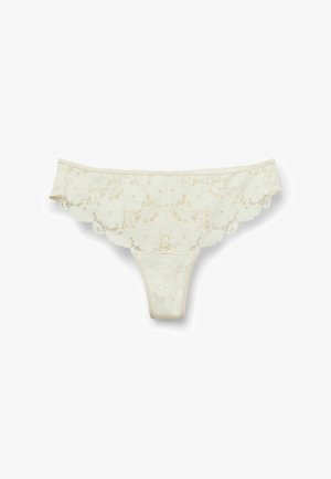 Crèmekleurige kanten string met bloemenpatroon en gezoomde randen op een witte achtergrond.