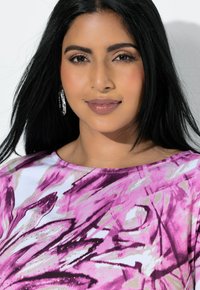 Vaaleanpunainen ja valkoinen kukkakuosinen paita, jossa laventelin sävyisiä pilkahduksia, pyöreä pääntie ja pienet kimaltelevat yksityiskohdat.