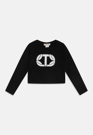 Crop top noir à manches longues avec logo stylisé blanc "T" dans un design rectangulaire arrondi sur la poitrine et un col rond.