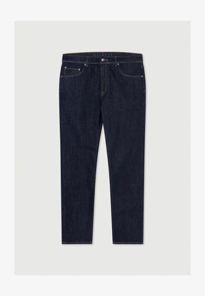 Tummansiniset farkut, joissa on kapea malli. Niissä on nappi- ja vetoketjukiinnitys, viisi taskua sekä hillitty oranssi ommelkoristelu.