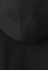 Hoodie noir avec une texture lisse et douce. Comprend une grande capuche, des poignets côtelés et des détails de couture subtils le long des coutures.