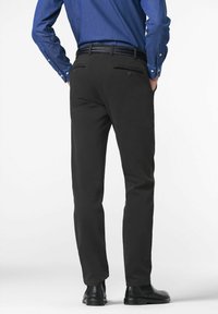 Pantalons noirs en tissu lisse, dotés de deux poches arrière et d'une ceinture tressée. Portés avec une chemise bleu boutonnière et des chaussures noires.