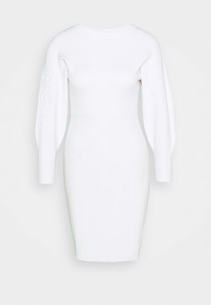 Abito bianco aderente con maniche lunghe e strutturate. Presenta un logo in rilievo sulla manica e un corpo testurizzato per un aspetto elegante e moderno.