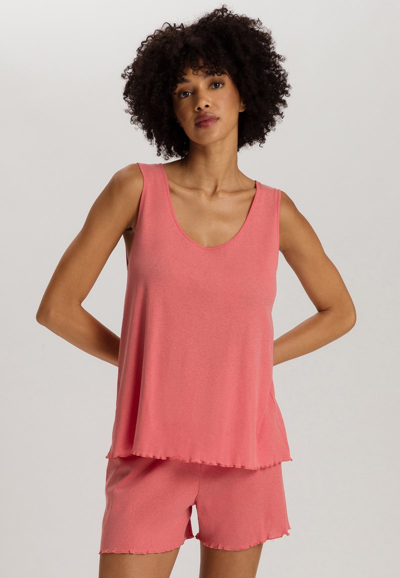 Top sin mangas de color rosa con escote redondeado, diseño en capas, combinado con pantalones cortos a juego. Hecho de una tela suave con un acabado ligeramente texturizado.