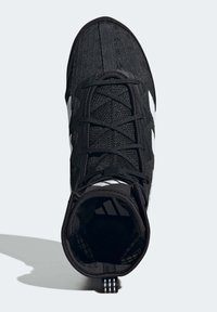 Musta urheilukenkä, jossa on rakenteellinen kangaspäällinen, mustat nauhat ja kolme valkoista viivaa sivulla. Pyöreä kärki ja pehmustettu varsi.