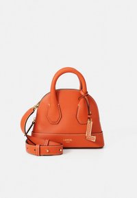 Malá oranžová kožená kabelka s kulatými úchyty, odnímatelným ramenním popruhem, zlatým kováním a dekorativním přívěskem ve tvaru "L" visícím na boku.