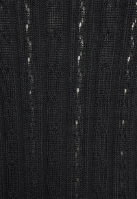 Tecido tricotado preto com padrões verticais e detalhes em rendado. A textura é leve com uma aparência canelada.
