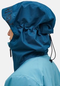 Blue waterproof jacket with a hood, featuring elastic gathers, adjustable drawstring, and logo detail on the side. Smooth, matte texture.