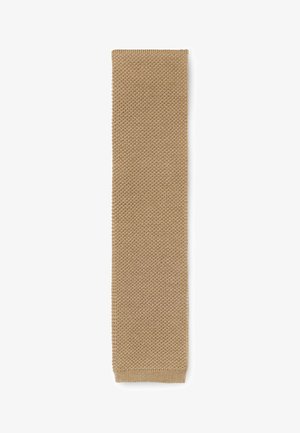 Strickschal in einer weichen, beigen Farbe. Rechteckige Form mit einem strukturierten Muster, das über einen gerippten Rand für zusätzliche Details verfügt.