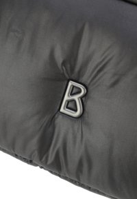 Giacca a vento nera in materiale piumino con texture trapuntata; presenta un logo metallico prominente con la lettera "B" al centro.