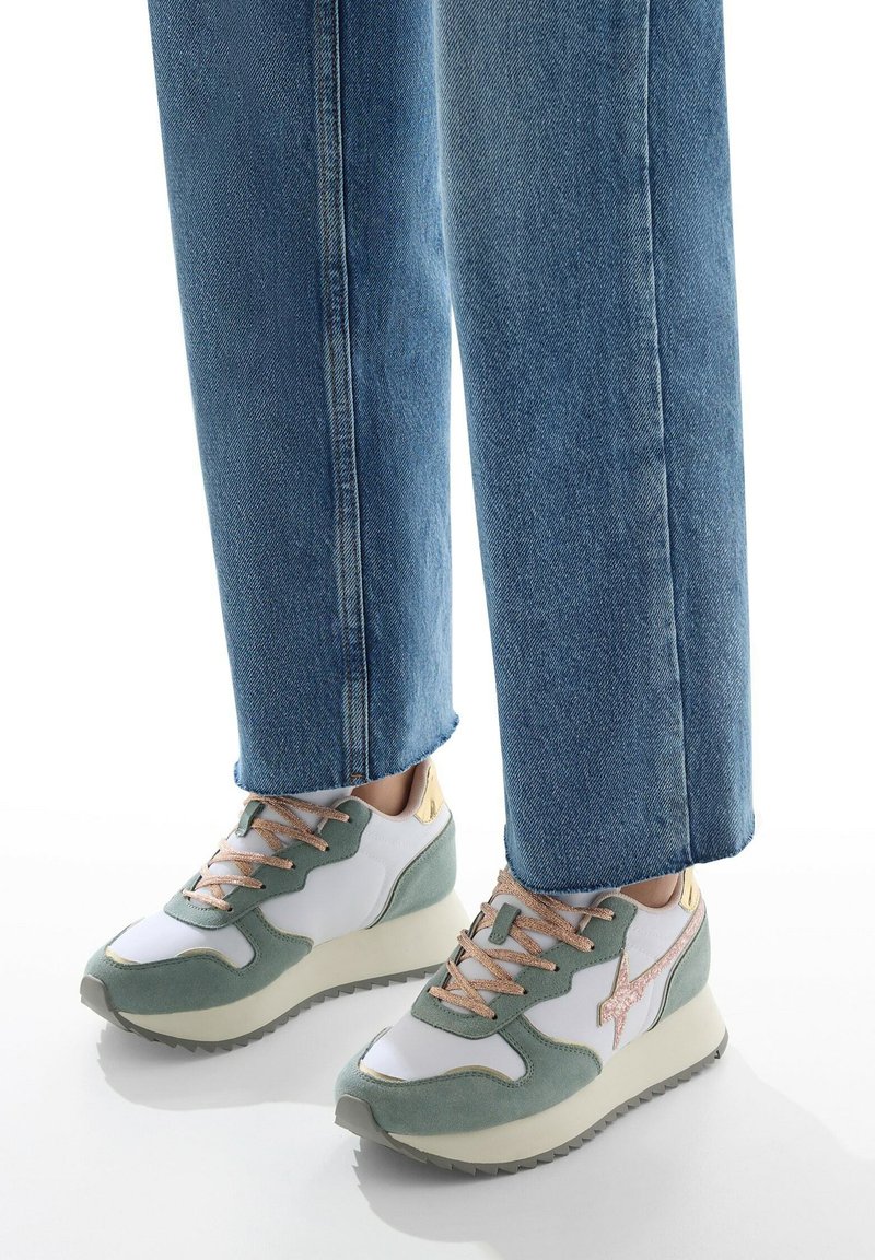 Sneaker sportivo con tomaia in suede e sintetico verde e bianco, lacci rosa e suola beige. Presenta un accento metallico dorato sul tallone.