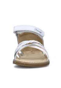 Sandal bianco con una cinghia testurizzata e dettagli intrecciati in argento. Chiusura regolabile con strappo. Design con suola piatta, adatto per un uso casual.