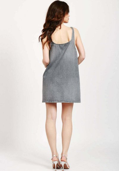 Abito in denim grigio senza maniche con una leggera forma a campana, orlo grezzo e cuciture semplici. Presenta una schiena aperta e un design minimalista.