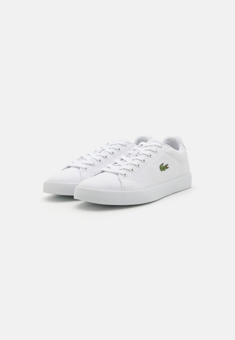 Weiße Canvas-Sneaker mit niedrigem Profil, abgerundeter Zehenpartie und strukturiertem Gummisohle. Verfügt über ein Schnürsystem und ein grünes Logodetail an der Seite.
