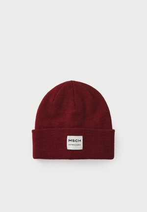 Burgundy knit beanie with a folded cuff and a square fabric label displaying "MSCH COPENHAGEN" in black text on a white background.