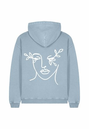 Felpa blu chiaro con cappuccio e cordoncino, e polsini a costine. Presenta un disegno in linea bianca di un volto con foglie su ciascun lato.