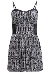Robe sans manches à motif géométrique noir et blanc avec fines bretelles, corsage ajusté et jupe froncée.