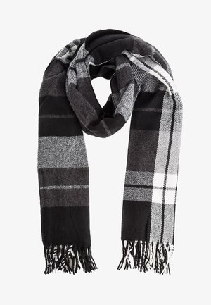 Bufanda a cuadros en negro, gris y blanco con extremos deshilachados, doblada de manera suelta con un lazo en la parte superior sobre un fondo blanco.