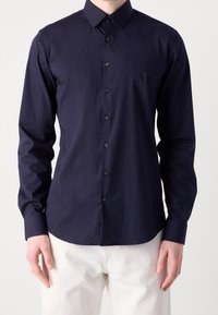 Marineblauw overhemd met lange mouwen en een button-down kraag, gemaakt van gladde stof, met een subtiel logo en bijpassende zwarte knopen.