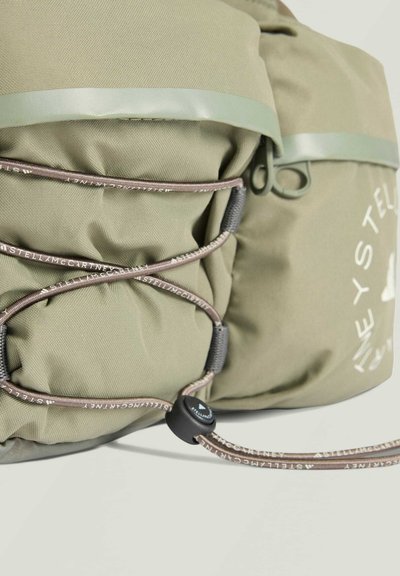 Olive green backpack with elastic cord detailing, featuring a matte texture, adjustable hardware, and printed logo on the side.