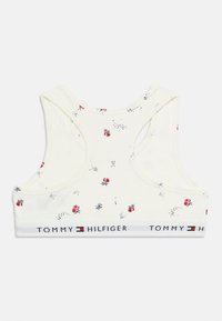 Λευκό αθλητικό σουτιέν racerback με μικρά κόκκινα ανθικά σχέδια και λωρίδα με το λογότυπο Tommy Hilfiger στο κάτω άκρο.