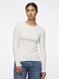 Pitkähihaiset, resorikuvioiset yläosa off-white-väriss�ä, valmistettu teksturoidusta kankaasta. Tiukka malli, jossa pyöreä pääntie ja pidennetyt kalvosimet, yhdistetty sinisiin farkkuihin.