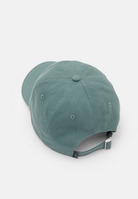 Zöld pamut baseball sapka ívelt karimával, öt panellel, gombbal a tetején és állítható pánttal, melyen fém hardver található hátul.