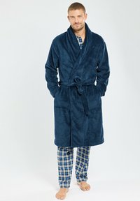 Peignoir de bain en velours bleu marine avec un col châle, une ceinture à nouer et deux poches avant. Assorti à un pantalon de pyjama à motifs écossais.