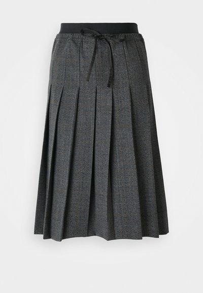 Jupe plissée grise avec un motif à carreaux texturé, dotée d'une taille élastique noire et d'un détail de nœud décoratif à l'avant.