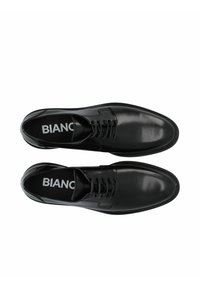 Scarpe in pelle nera con finitura liscia, caratterizzate da un design con lacci e punta rotonda, con una soletta marchiata con il testo 'BIANCO'.