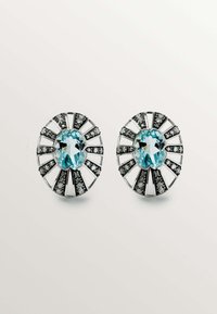 Pendientes en tono plateado con una gema central de color azul claro, rodeada de acentos negros y detalles plateados en forma de abanico.