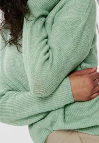 Pull en tricot vert menthe à la coupe décontractée, avec un motif côtelé texturé et un large encolure, doté de manches longues et d'une apparence douce et confortable.