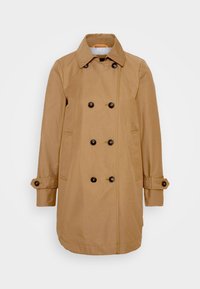 Béžový dvouvrstvý trenčkot s černými knoflíky, bočními kapsami a nastavitelnými manžetami na knoflíky, zobrazený na jednoduchém bílém pozadí.