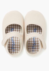 Jasno beżowe buty z tkaniny, z okrągłymi noskami, rzepem i brązowymi wstawkami w kratkę. Gładka powierzchnia z minimalnym zdobieniem.