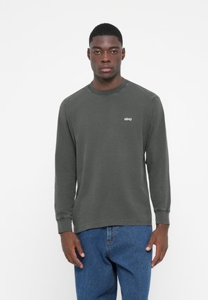 Mørkegrøn langærmet T-shirt lavet af blødt bomuld, med rund halsudskæring og et lille hvidt "obey" logo på brystet.