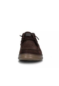 Scarpa in pelle marrone con punta tondeggiante, lacci sopra e una suola spessa in gomma beige. Presenta dettagli di cucitura lungo il bordo superiore.