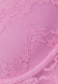 Rosa spetstyg med blommönster, strukturerad nät och en svängd kant. Designen betonar intrikata detaljer och en mjuk yta.