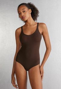 Brun bodysuit med tunna axelremmar, slät textur och rundad halsringning. Slimmad design med kort skärning.