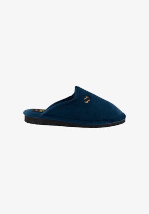 Zapatilla de felpa azul marino con parte trasera abierta, punta redondeada y suela de goma negra. Presenta un pequeño logotipo dorado en el lateral.